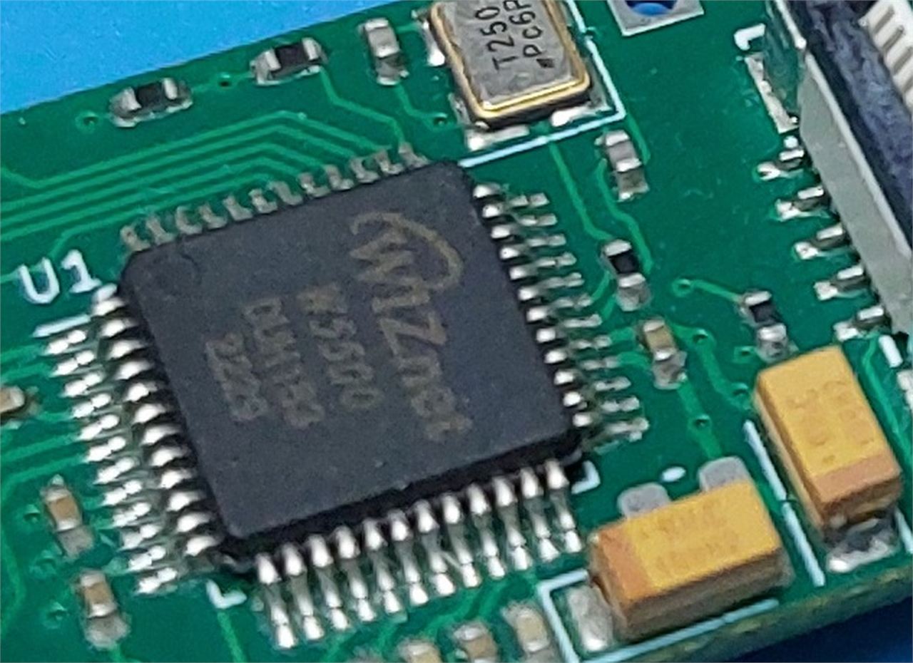 Close macro view of a green PCB showing a black LQFP chip marked with the WIZnet logo and the part number W5500, with reference designator U1 silkscreened beside it and a 25 MHz crystal above