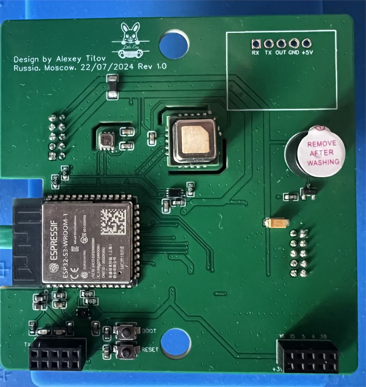 Photograph of the bare front board before the radar module was fitted, showing the silkscreen credit reading Design by Alexey Titov, Russia, Moscow, 22/07/2024 Rev 1.0, a rabbit logo, and the five solder pads labelled RX TX OUT GND +5V