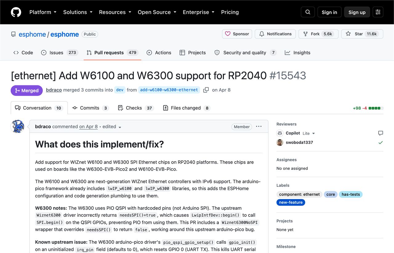 Screenshot of the merged GitHub pull request 15543, titled Add W6100 and W6300 support for RP2040, showing the merged badge, the 98 added lines, and the opening paragraphs that explain the PIO QSPI workaround