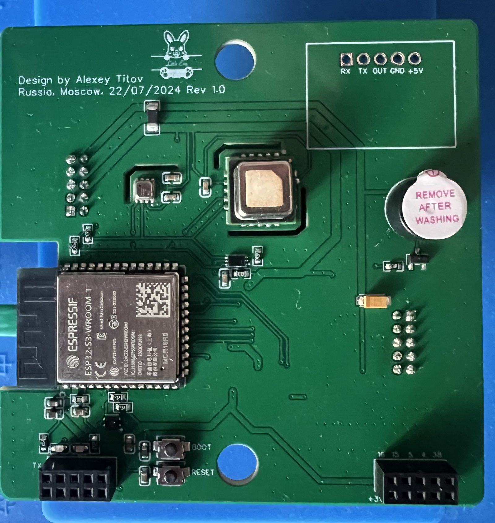 Photograph of the bare front board before the radar module was fitted, showing the silkscreen credit reading Design by Alexey Titov, Russia, Moscow, 22/07/2024 Rev 1.0, a rabbit logo, and the five solder pads labelled RX TX OUT GND +5V
